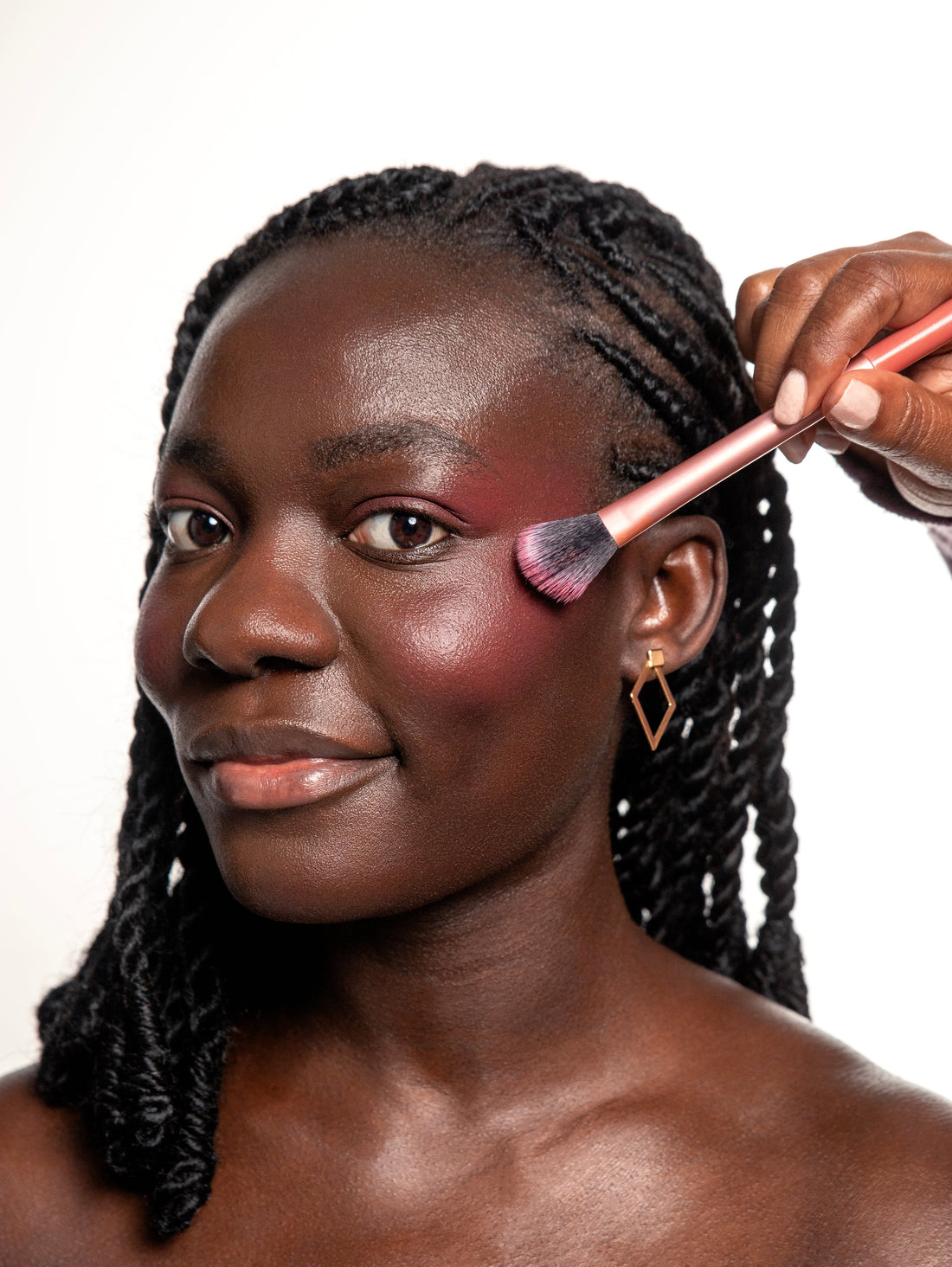 Image of a makeup artist applying Adwo Makeup blush in Berry Petal(AB030) on a beautiful dark skin model.